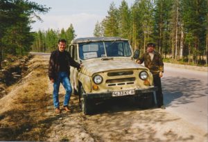 Kaksi miestä seisoo molemmin puolin vanhaa autoa