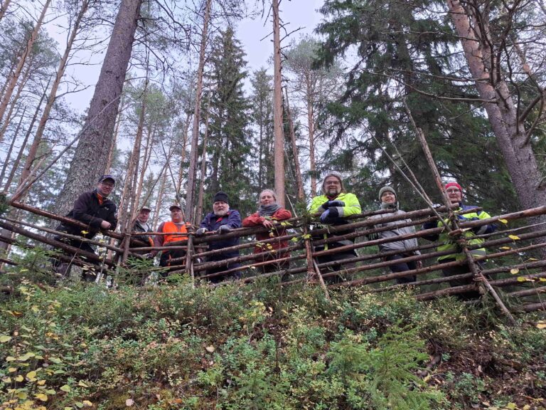 ihmisiä pistoaidan takana