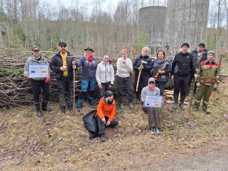 Ihmisiä lahopuuaidan edessä